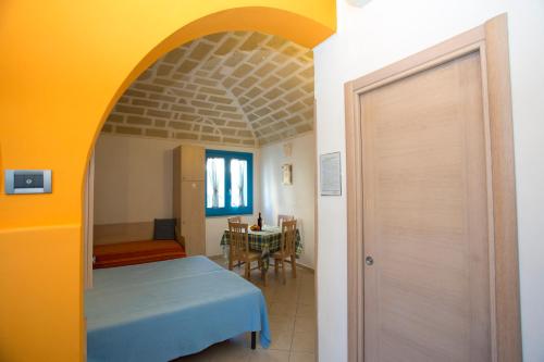 a room with a bed and a table and a door at Terra del Sole in Favignana
