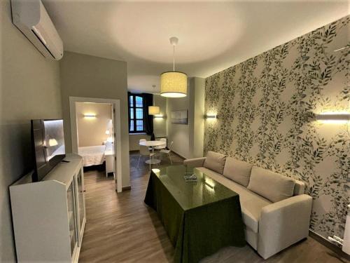 - un salon avec un canapé et une table dans l'établissement Apartamentos Sol del Prior, à Úbeda