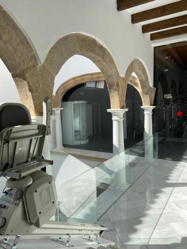 a salon with a chair in a room with arches at Apartamentos Sol del Prior in Úbeda
