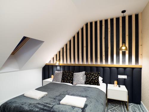 a bedroom with a bed and a striped wall at Aparthotel Góralski Spa 2 in Białka Tatrzanska