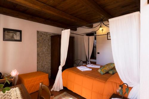 a bedroom with an orange bed and curtains at Agriturismo Montagna Verde Apella in Licciana Nardi