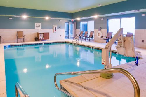 una piscina en una habitación de hospital con sillas en Holiday Inn Express & Suites Russellville, an IHG Hotel en Russellville