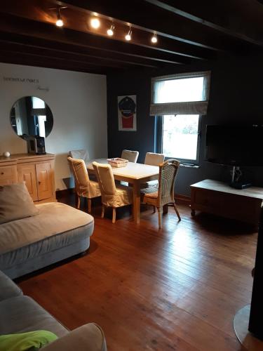 a living room with a dining room table and chairs at ’t Wielerpension in Steenhuize-Wijnhuize