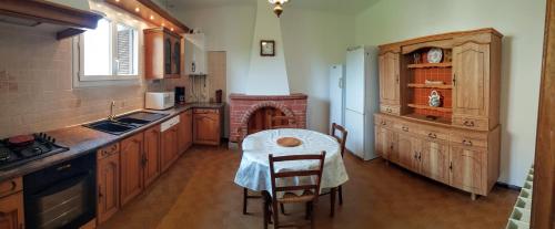 a kitchen with a table and a kitchen with a stove at Grande Maison de vacances in Santa-Maria-Siché