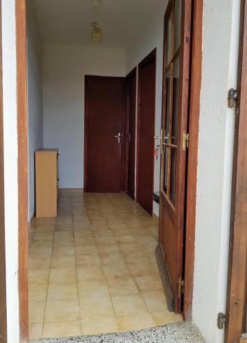 an empty hallway with two doors and a wooden floor at Grande Maison de vacances in Santa-Maria-Siché