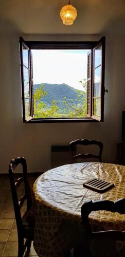 a table and chairs in a room with a large window at Grande Maison de vacances in Santa-Maria-Siché