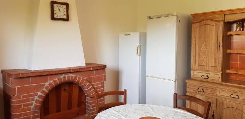 a kitchen with a brick fireplace and a refrigerator at Grande Maison de vacances in Santa-Maria-Siché