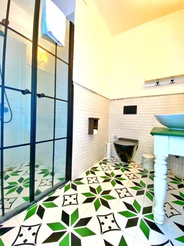 Łazienka z podłogą wyłożoną zielonymi i białymi kafelkami. w obiekcie Kesre Hotel w mieście Alaçatı