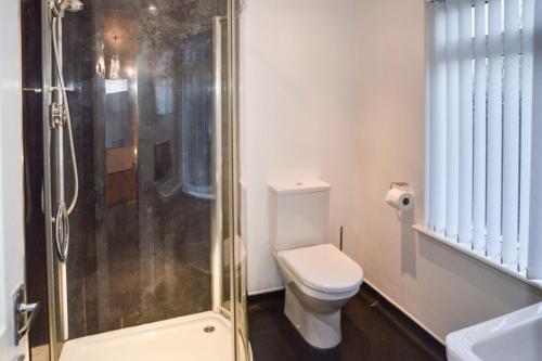 a bathroom with a toilet and a glass shower at Sea View Bungalow in Hougham