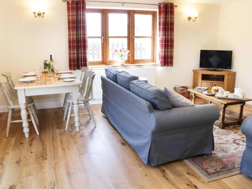 a living room with a couch and a table at The Cider House in Leominster