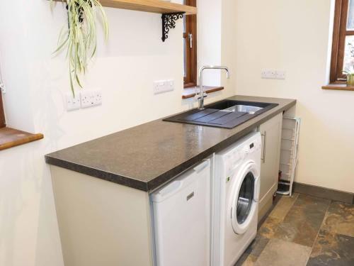 a kitchen with a sink and a washing machine at The Cider House in Leominster
