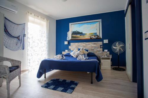 1 dormitorio azul con 1 cama y chimenea en La casa del pescatore, en Oliveri