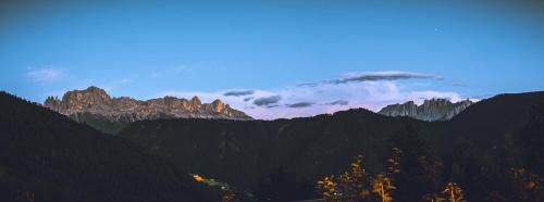 a view of a mountain range with trees and clouds at Ansitz Velseck-Residence Hotel in Tires