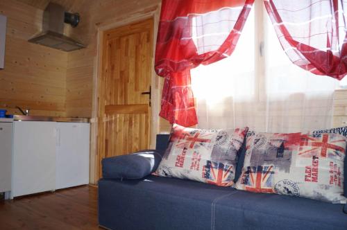 a blue couch in a living room with a window at Mini Kemping Laguna in Mielno