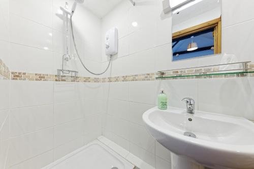 a white bathroom with a sink and a shower at Beachborough Park in Folkestone