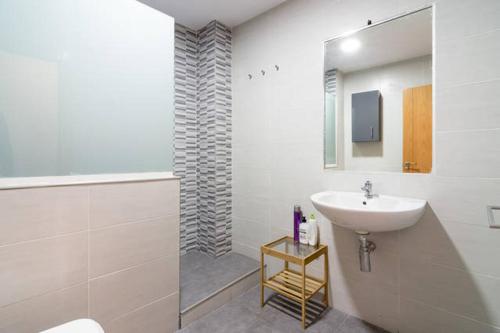y baño blanco con lavabo y ducha. en Apartamento Postigos, en Málaga