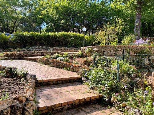 a garden with a brick walkway and some plants at Villa Lilia by Let in Siena