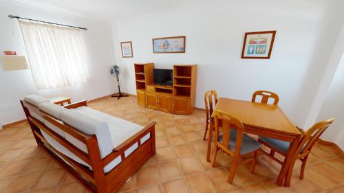 a living room with a table and chairs and a television at Monte dos Avós Village - Pet Friendly in Tavira