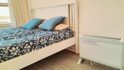 a bed with pillows and a radiator in a room at Miramar con Vista al mar in Miramar