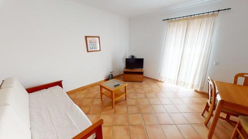 a living room with a couch and a table at Monte dos Avós Village - Pet Friendly in Tavira