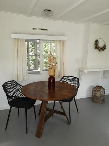 a dining room with a wooden table and two chairs at Het Nijhuisje in Markelo