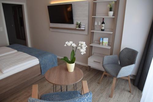 a small bedroom with a bed and a table and a chair at Hotel Thode in Dahme