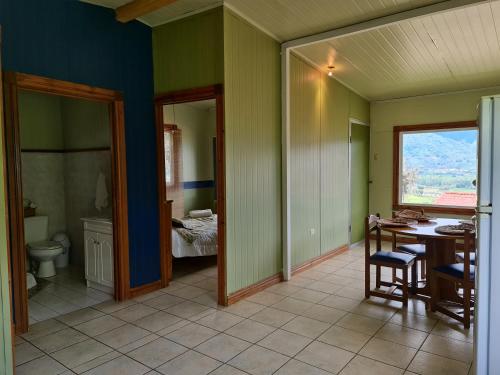 a room with a table and a bathroom with a bed at Villas Valle Bello in Ujarrás