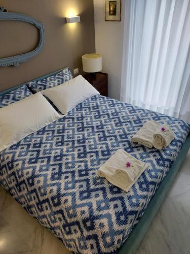 ein blau-weißes Bett mit Handtüchern darauf in der Unterkunft IL LEUDO in Lavagna
