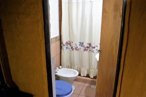 y baño con aseo y cortina de ducha. en Kpriccio Cabanas en Potrerillos