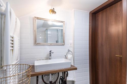 y baño con lavabo blanco y espejo. en PelsoArt Apartments en Keszthely