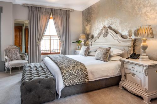 1 dormitorio con 1 cama blanca grande y 1 silla en Castello Di Monte, en Pretoria