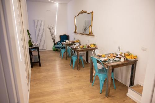 uma sala de jantar com mesas e cadeiras e um espelho em Ai Tre Mercati em Palermo