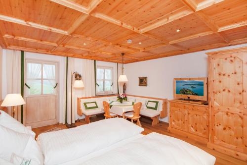 a bedroom with a bed and a table with chairs at Gschwendtnerhof App8 Fuß in Aschau im Chiemgau