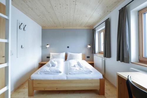 a bedroom with a bed with white sheets at Chalet Sonnblick in Stuben am Arlberg