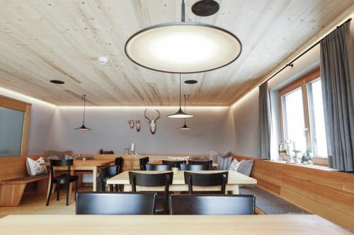 a restaurant with wooden ceilings and tables and chairs at Chalet Sonnblick in Stuben am Arlberg