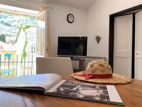 a hat sitting on top of a table with a book at Appartamenti Sentiero n1 in Levanto