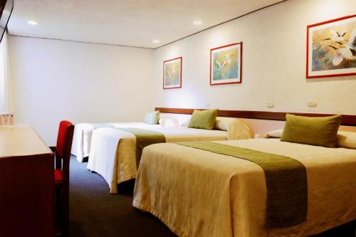 una habitación de hotel con 3 camas en una habitación en Hotel Manalba en Ciudad de México
