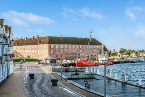 a marina with a building and a boat in the water at Grannys Harbour View - 1st floor in Sønderborg