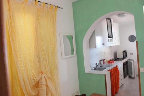 uma cozinha com uma cortina de chuveiro e um lavatório em TELLINA PALMARE BEACH em Lampedusa