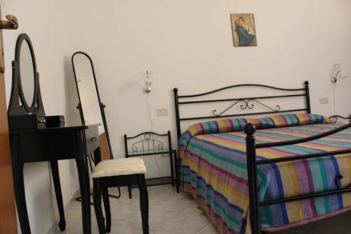 sypialnia z łóżkiem, stołem i lustrem w obiekcie TELLINA PALMARE BEACH w mieście Lampedusa