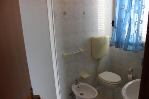 uma pequena casa de banho com WC e lavatório em TELLINA PALMARE BEACH em Lampedusa