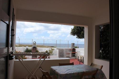 um quarto com uma mesa e vista para o oceano em TELLINA PALMARE BEACH em Lampedusa