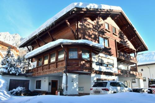 a snow covered house with a car parked in front of it at Residence Arche Noah - Colfosco in Colfosco