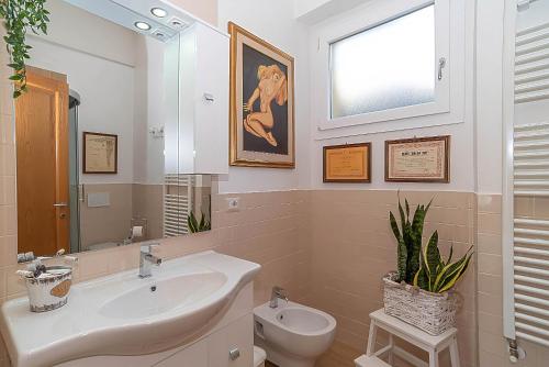 bagno con lavandino, servizi igienici e finestra di La casa del pittore a Olbia