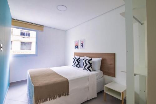 Habitación blanca con cama y ventana en 360 Suítes Santa Ifigênia - Apartamentos mobiliados, en São Paulo