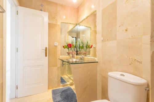 une salle de bain avec toilettes, lavabo et miroir dans l'établissement Appartement Altamira Orihuela Costa Golf, Las Ramblas, à Orihuela Costa