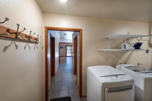 a laundry room with a washer and dryer and a hallway at Apple Tree Bear House in Yosemite West