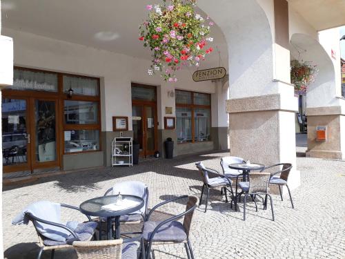 un grupo de mesas y sillas frente a un edificio en Penzion Hotelu Central en Dvůr Králové nad Labem