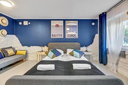 a bedroom with a large bed and a blue wall at Apartamenty przy Helskiej - Basement - Przyziemie in Sopot