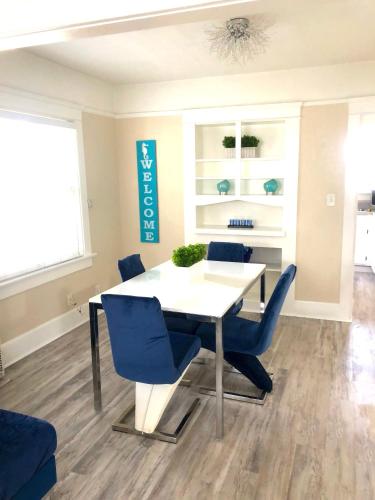 a dining room with a white table and blue chairs at Viva San Diego in San Diego